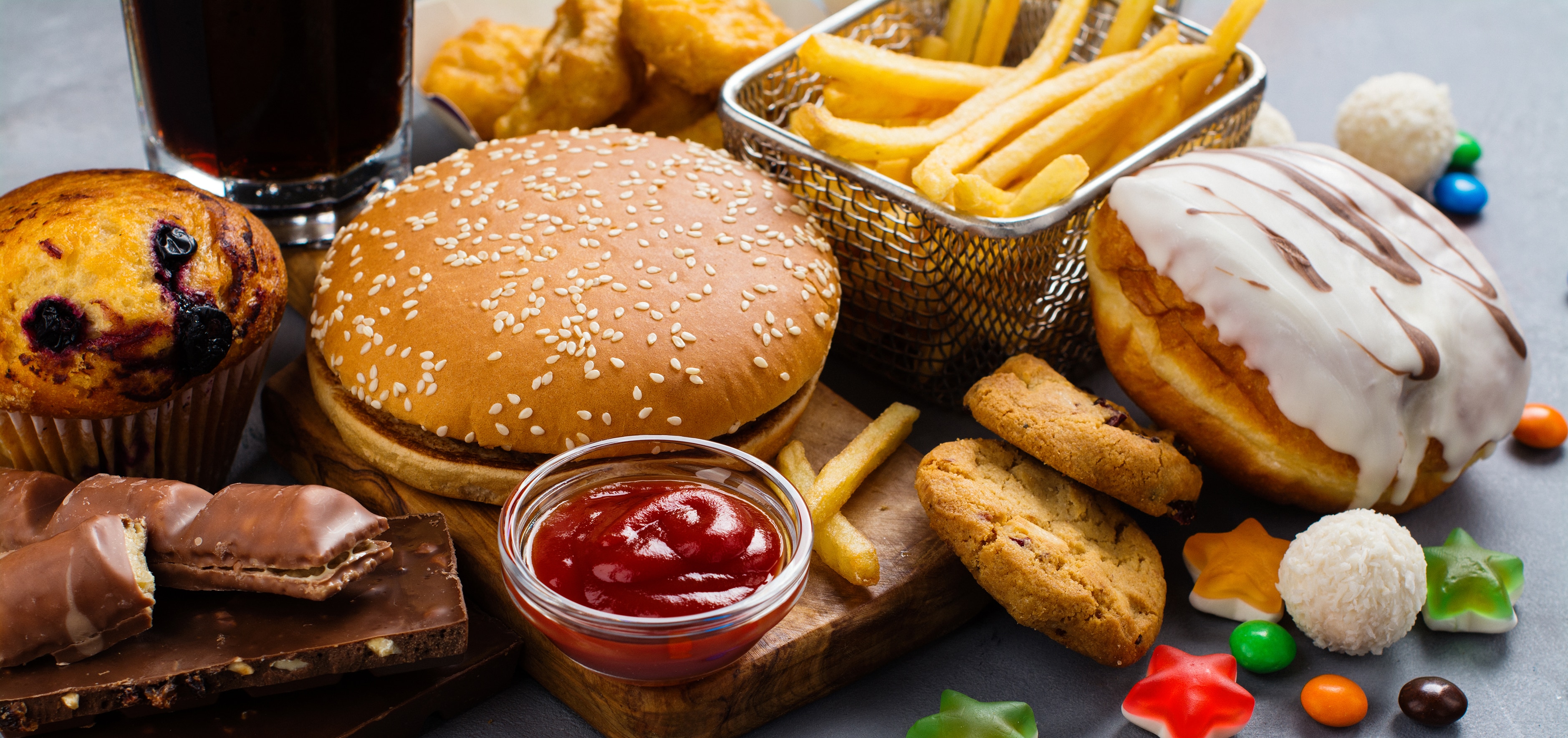 Junk foods including chocolate, hamburger, fried fast foods, iced doughnut, cola, and sugary sweets